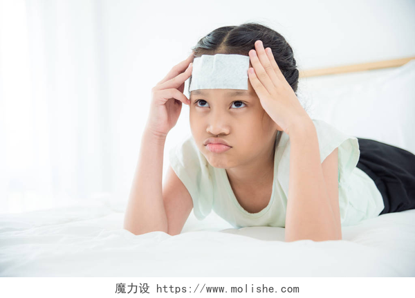 发烧的女孩趴在床上年轻的亚洲与凉爽的凝胶在额头上头痛躺在床上